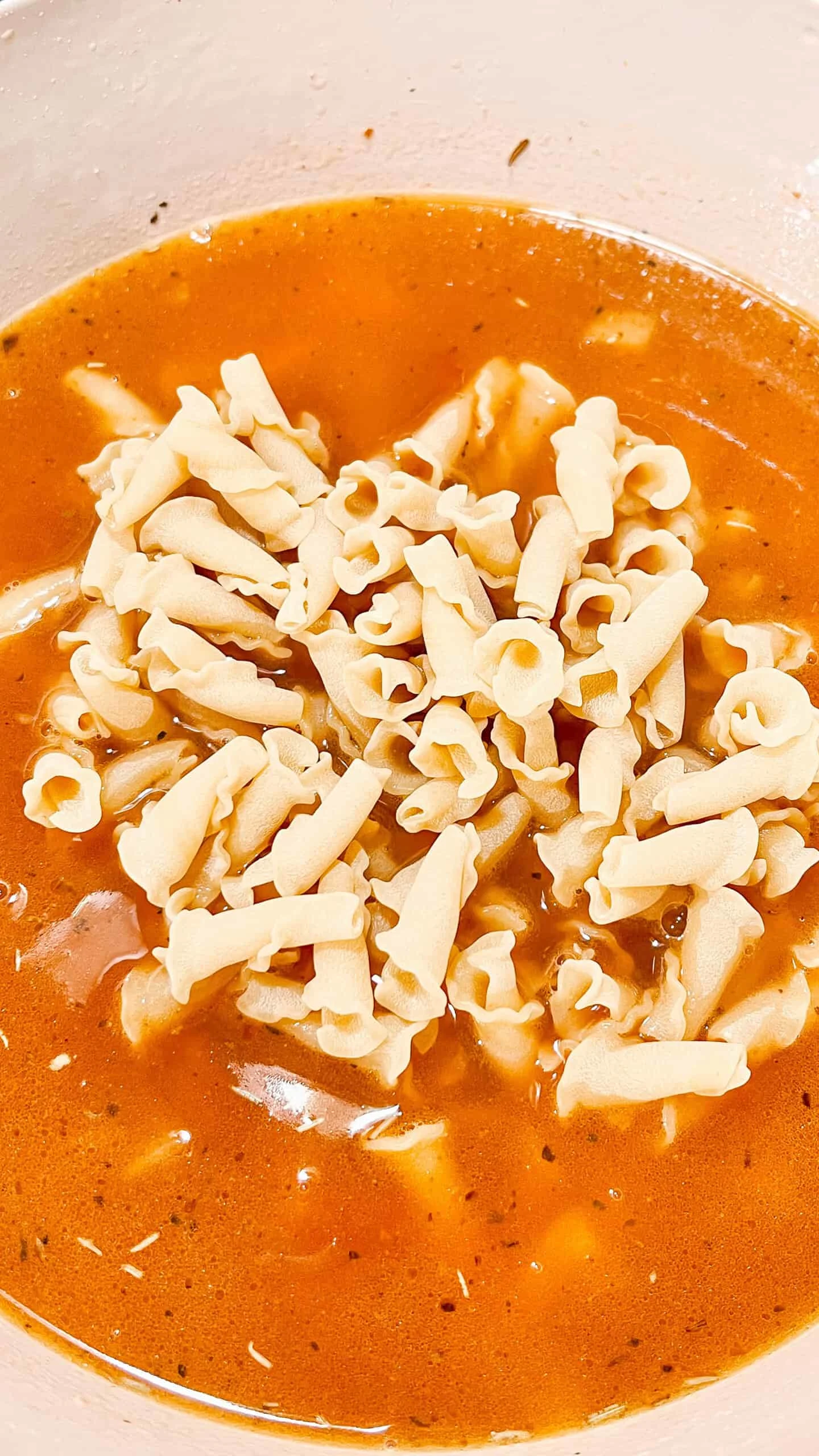 Image shows a bowl of creamy tomato soup topped with shredded cheese, highlighting comfort food recipes from Moore or Less Cooking.