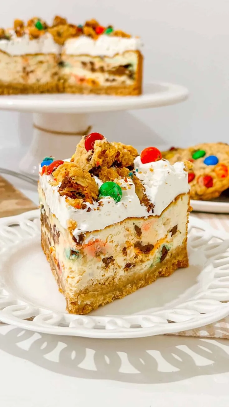 Delicious Monster Cookie Cheesecake with candy decorations, cookies and whipped cream frosting for celebrations.