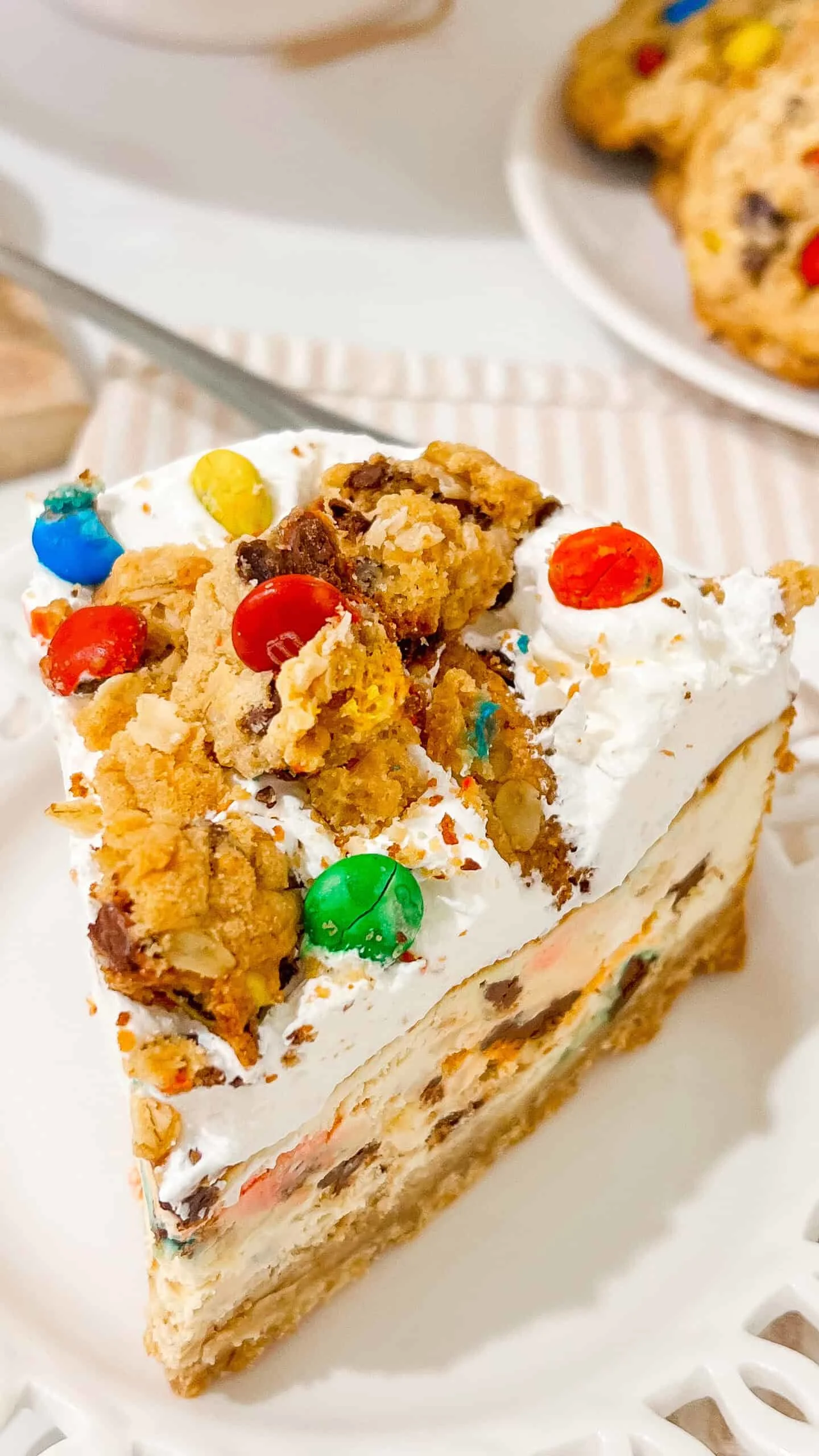 Delicious cookie cheesecake topped with colorful candies and whipped cream, perfect for celebrations.