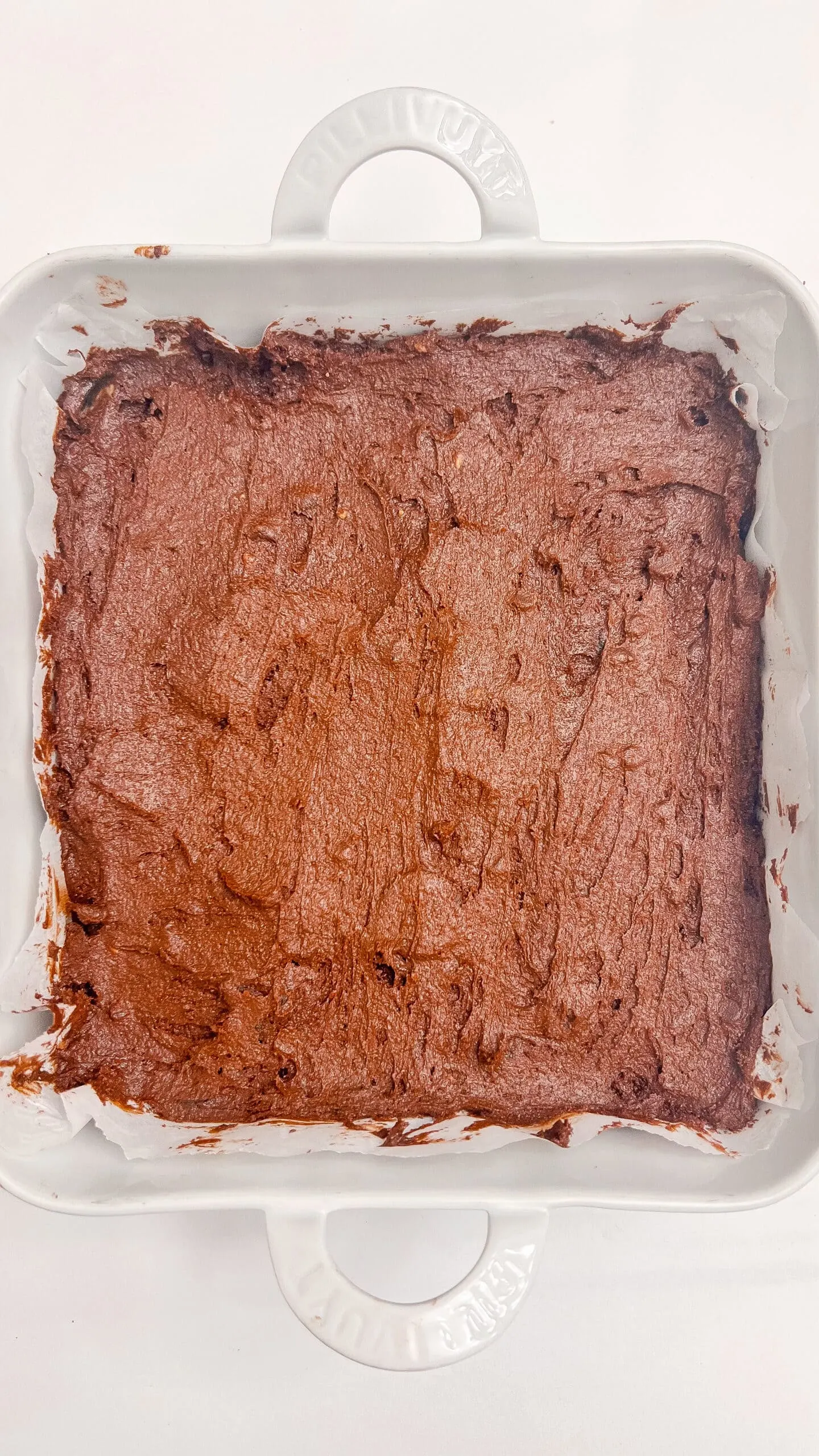 brownie batter in a white dish, perfect for dessert and sharing.