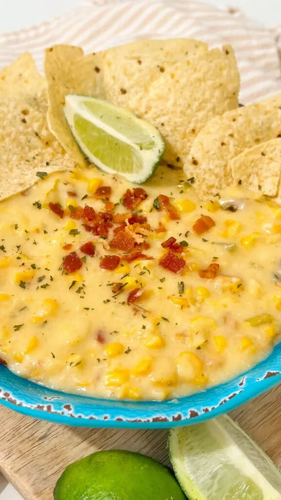 crockpot corn dip ready to serve Creamy crockpot corn dip recipe with cheese, bacon, and spices, ideal for parties and gatherings. Serve with tortilla chips.