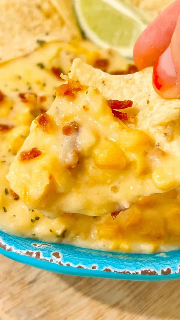 serving corn dip Creamy crockpot corn dip recipe with cheese, bacon, and spices, ideal for parties and gatherings. Serve with tortilla chips.