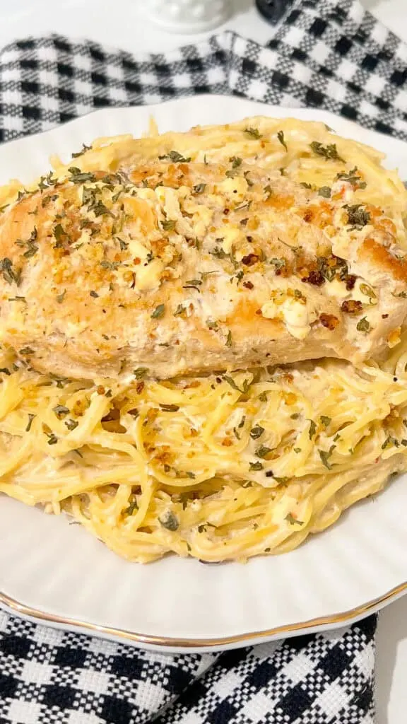 chicken and pasta on white plate black and white check napkin