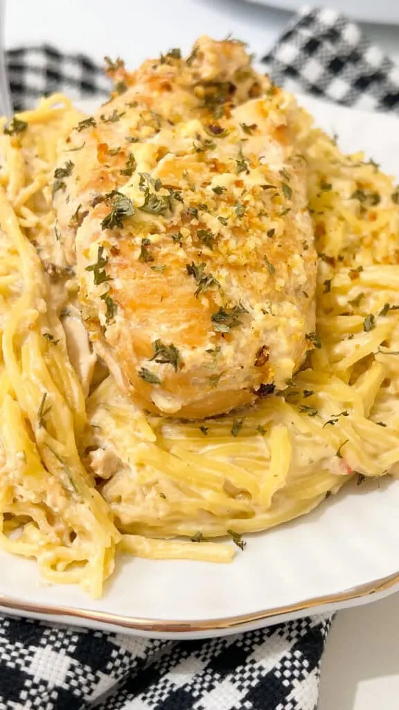 Crockpot Angel Chicken cooked over angel hair pasta with creamy garlic sauce