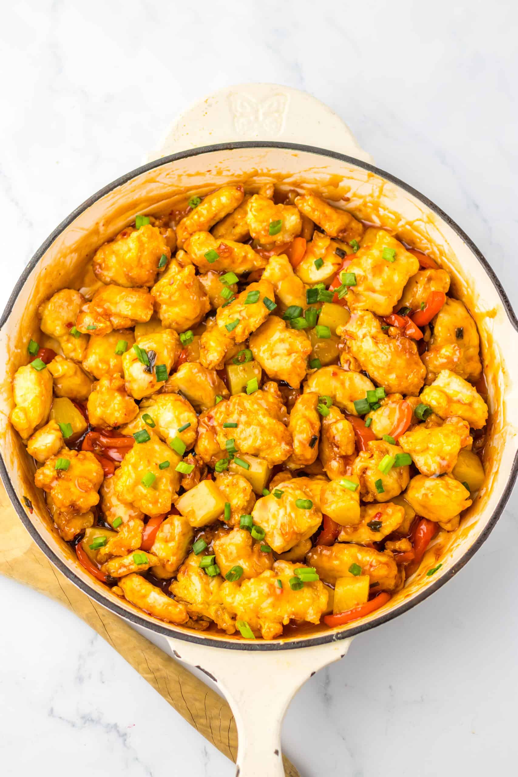 Delicious sweet chili chicken with crispy bites and fresh green onions.