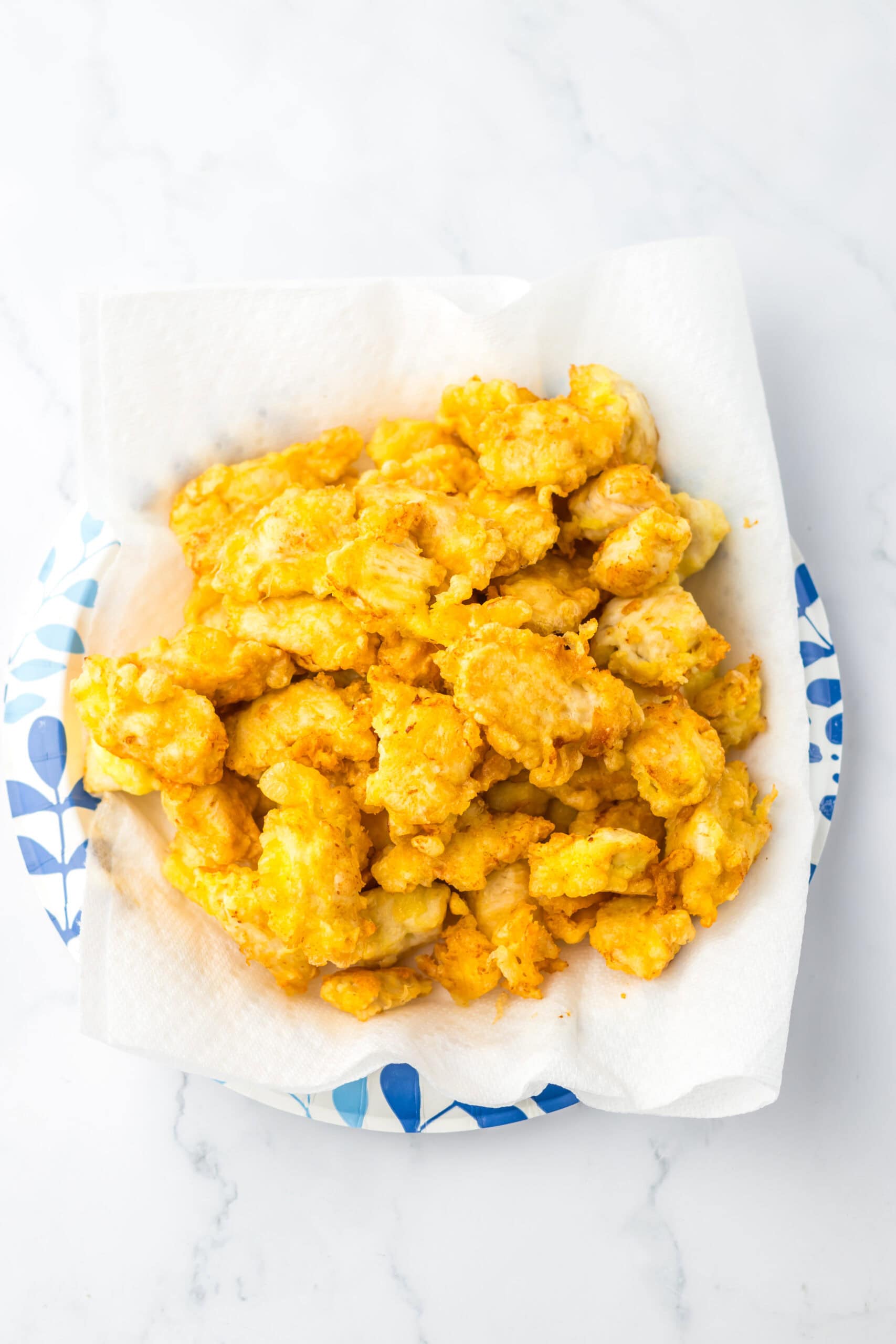 Crispy sweet chili chicken bites on paper towel, ready to serve.