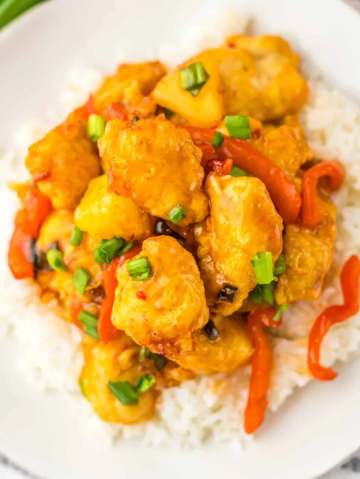 sweet chili chicken over rice on white plate
