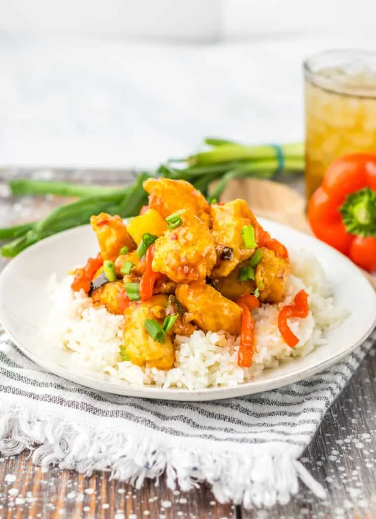 sweet chili chicken over rice on white plate gray striped placemat