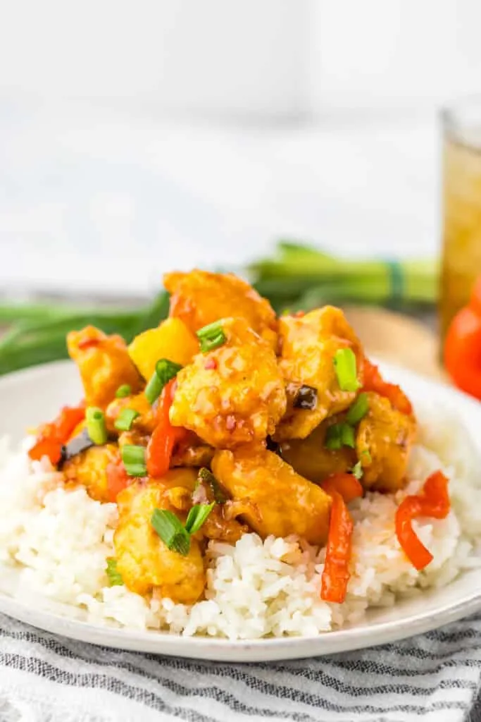 sweet chili chicken and veggies over rice on white plate