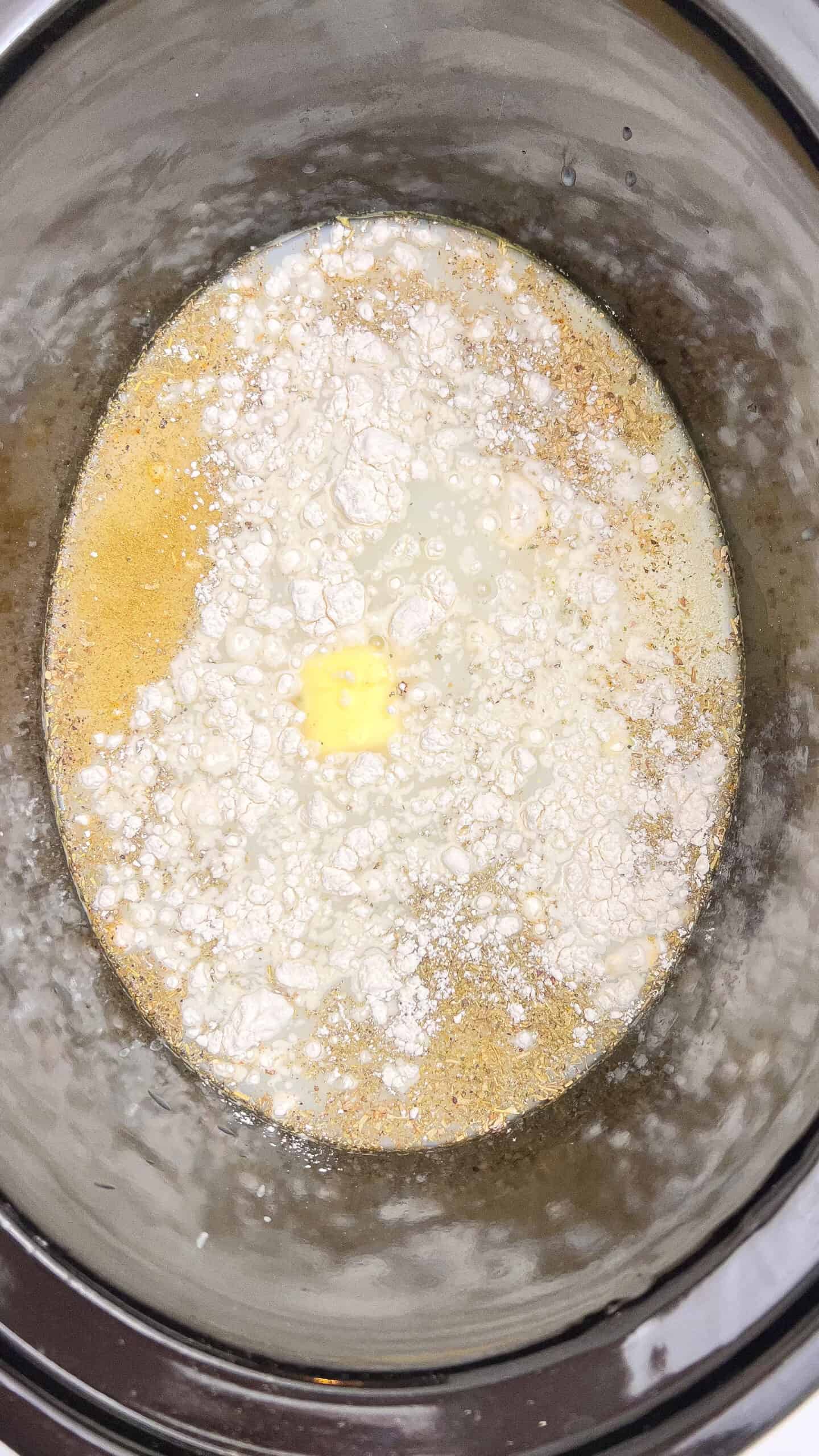 Creamy chicken Alfredo lasagna soup cooking in a slow cooker.