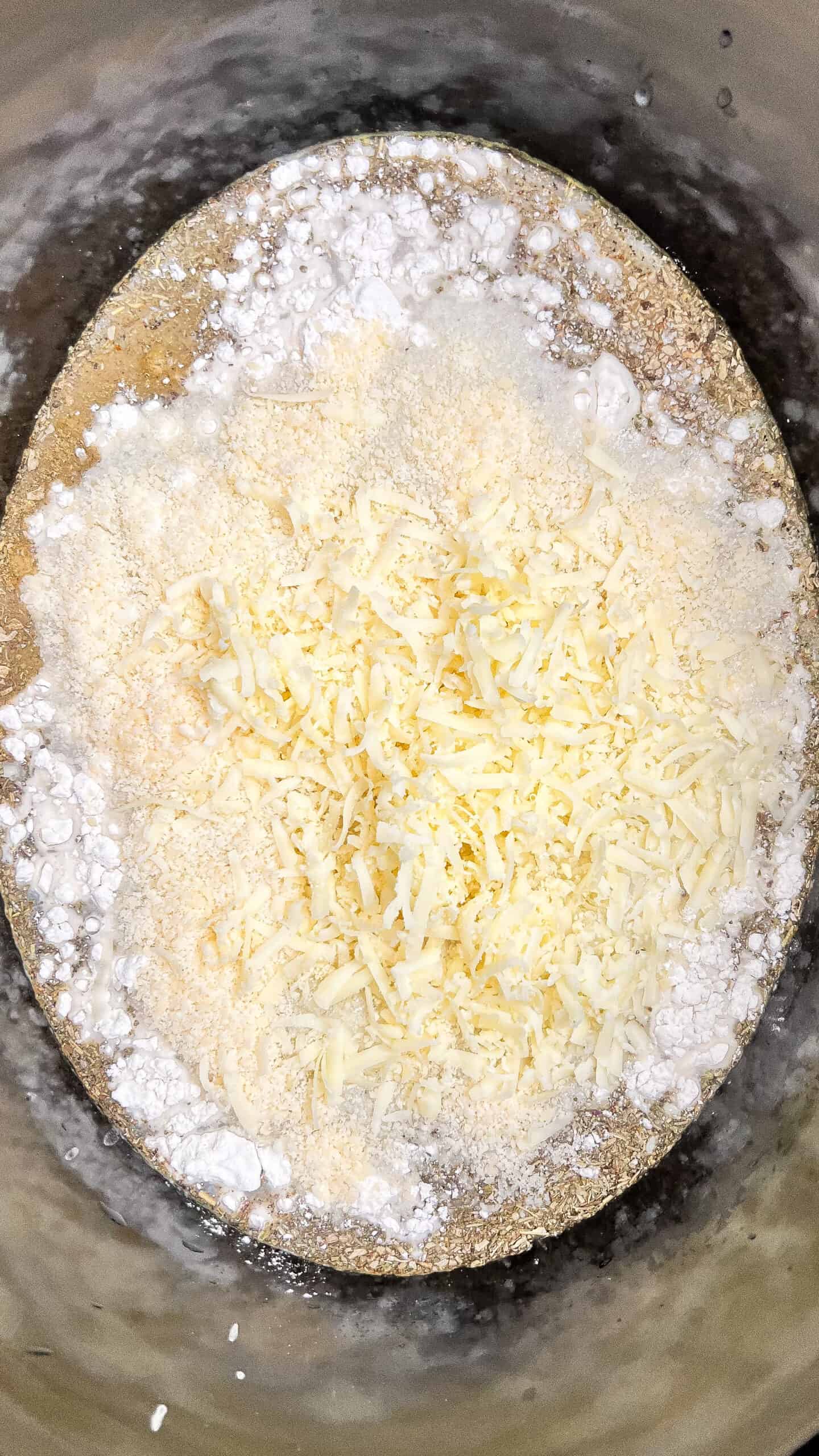 Shredded cheese and flour in a mixing bowl for Crockpot Chicken Alfredo Lasagna Soup.