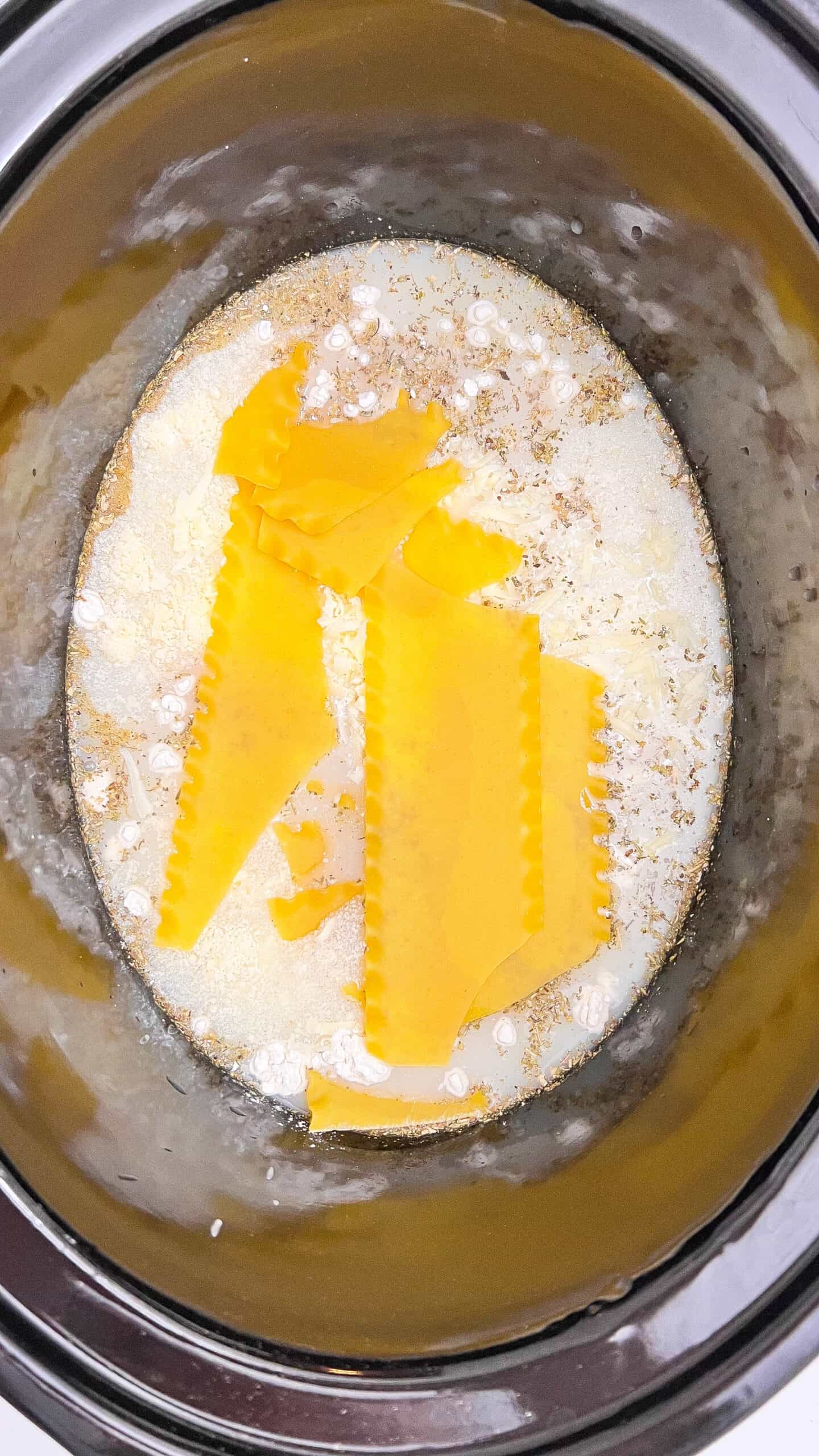 Butter, flour, and milk cooking in a pot for creamy Alfredo soup base.