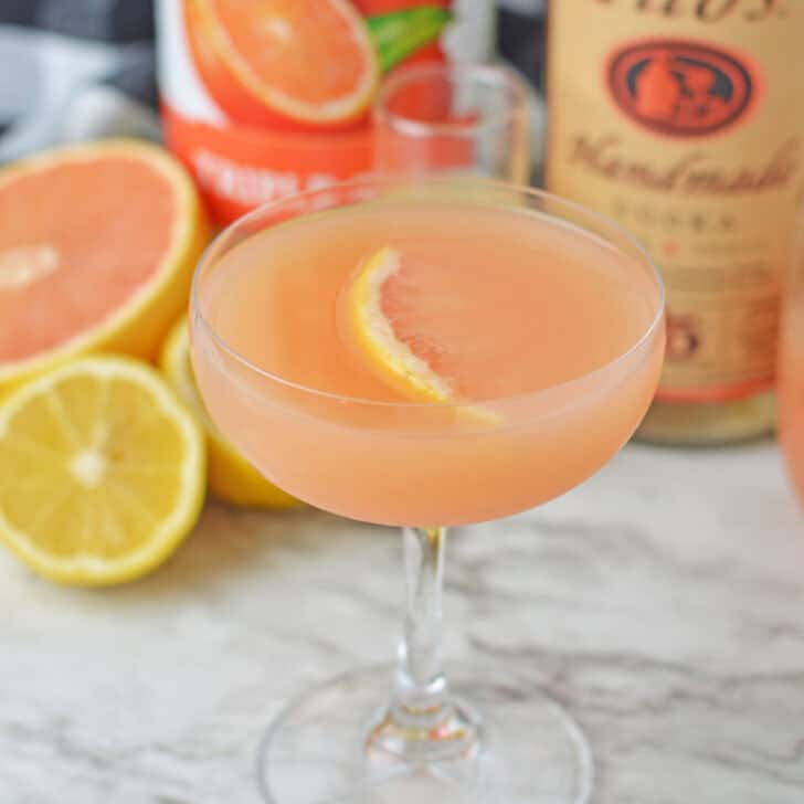 Refreshing grapefruit martini with citrus slice garnish on a cocktail glass.
