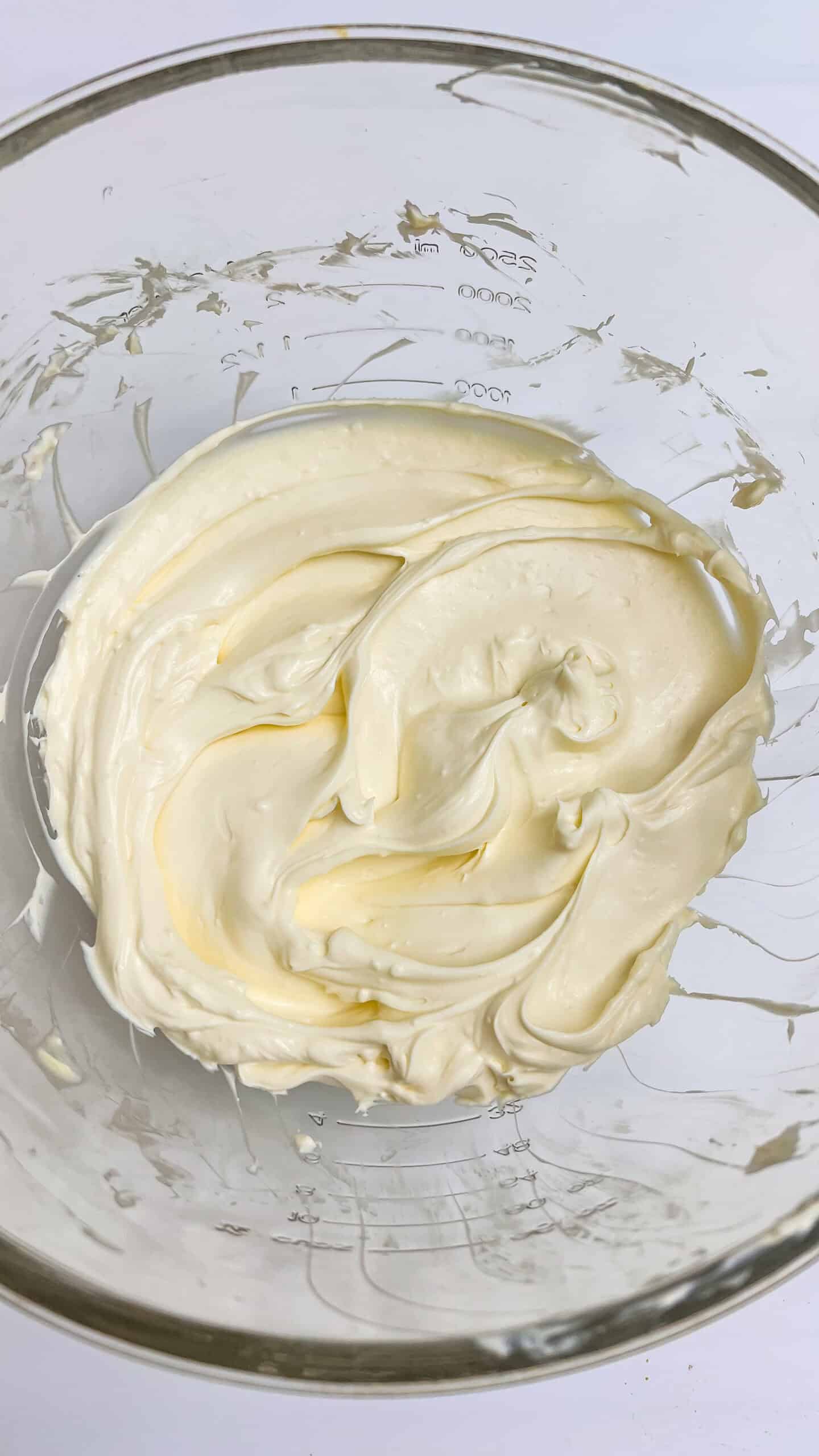 Cream cheese mixture in a glass bowl for Boston Cream Pie Cheesecake.