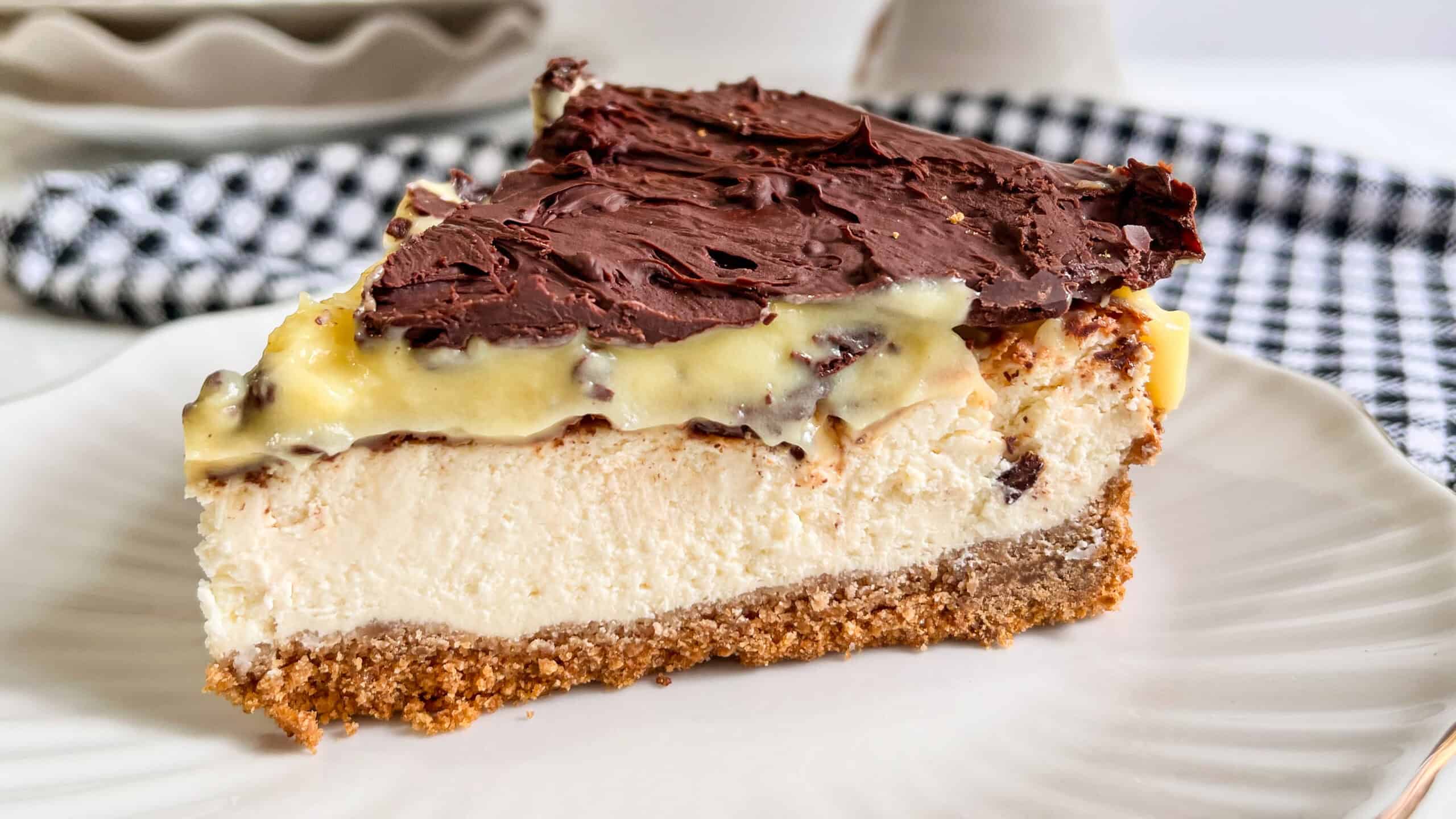 Delicious Boston Cream Pie Cheesecake with chocolate topping and creamy filling.