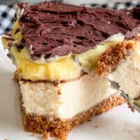 Delicious homemade cheesecake with rich chocolate topping and graham cracker crust.