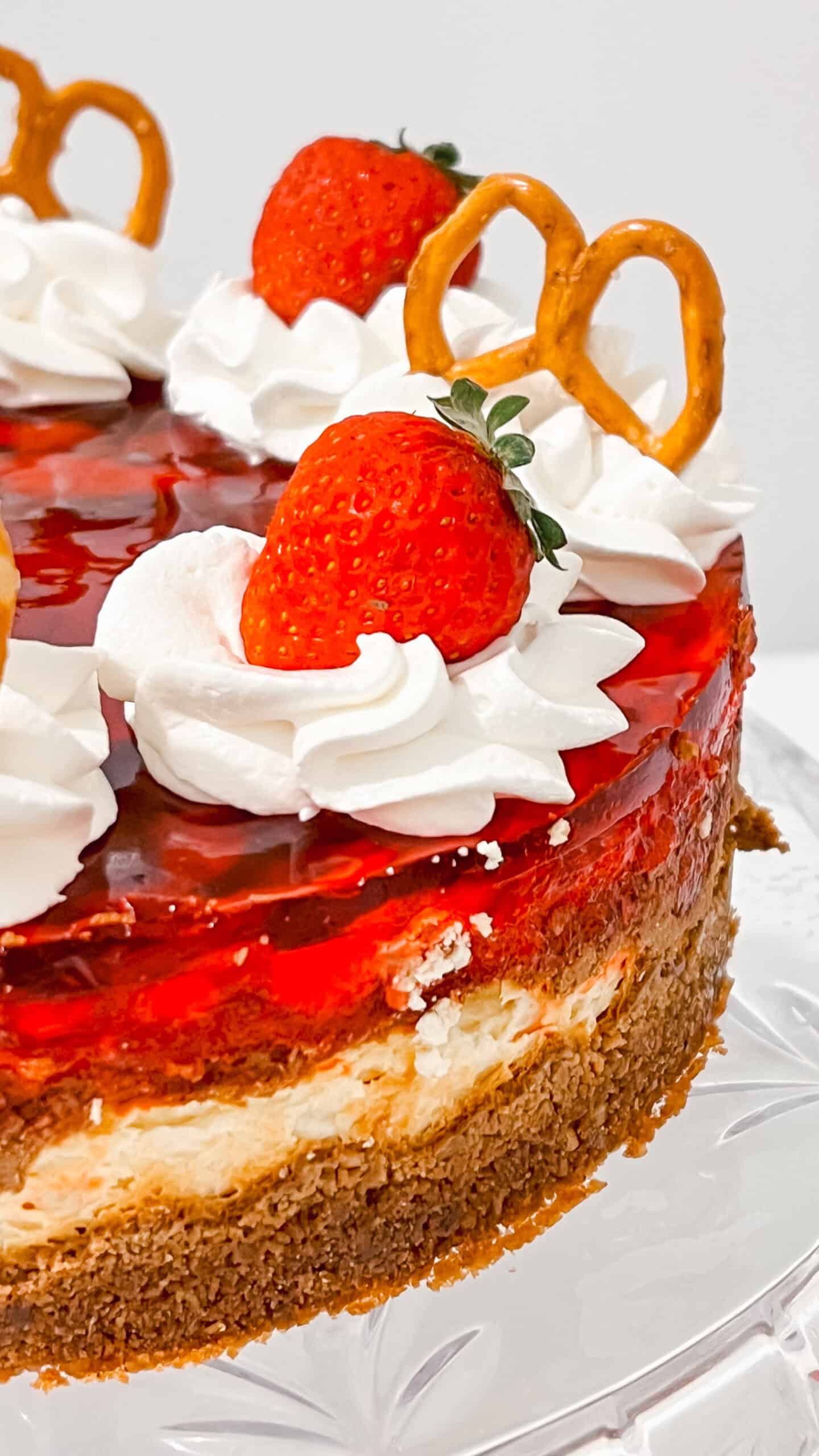Delicious strawberry cheesecake topped with fresh strawberries, whipped cream, and caramel pretzels.