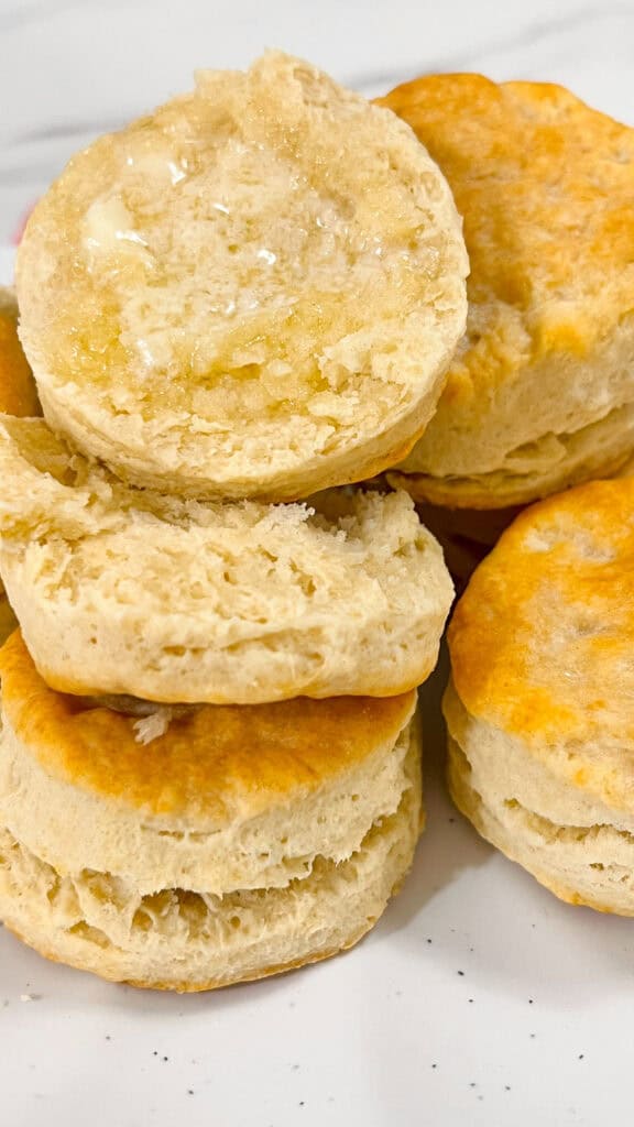 baked and stacked Sourdough Discard Buttermilk Biscuits buttered
