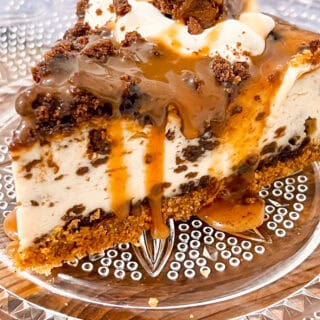 Delicious caramel brownie cheesecake slice with caramel drizzle and chocolate topping.