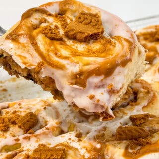Close-up of Biscoff cinnamon rolls topped with cookie butter and caramel drizzle.