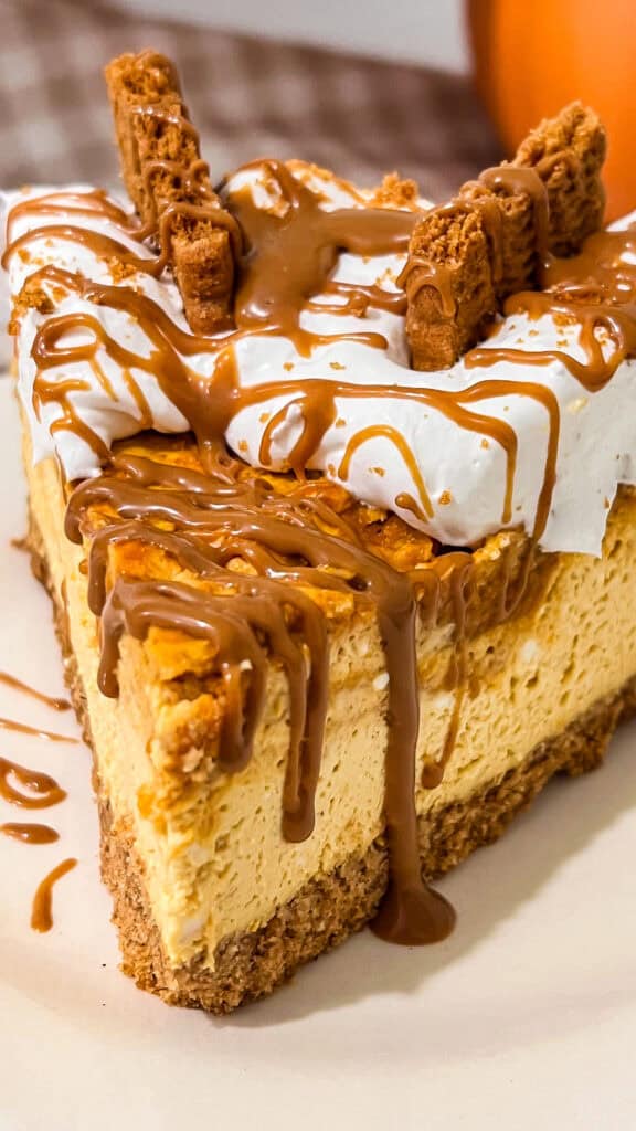 Delicious pumpkin Biscoff cheesecake with caramel drizzle and cookie toppings.